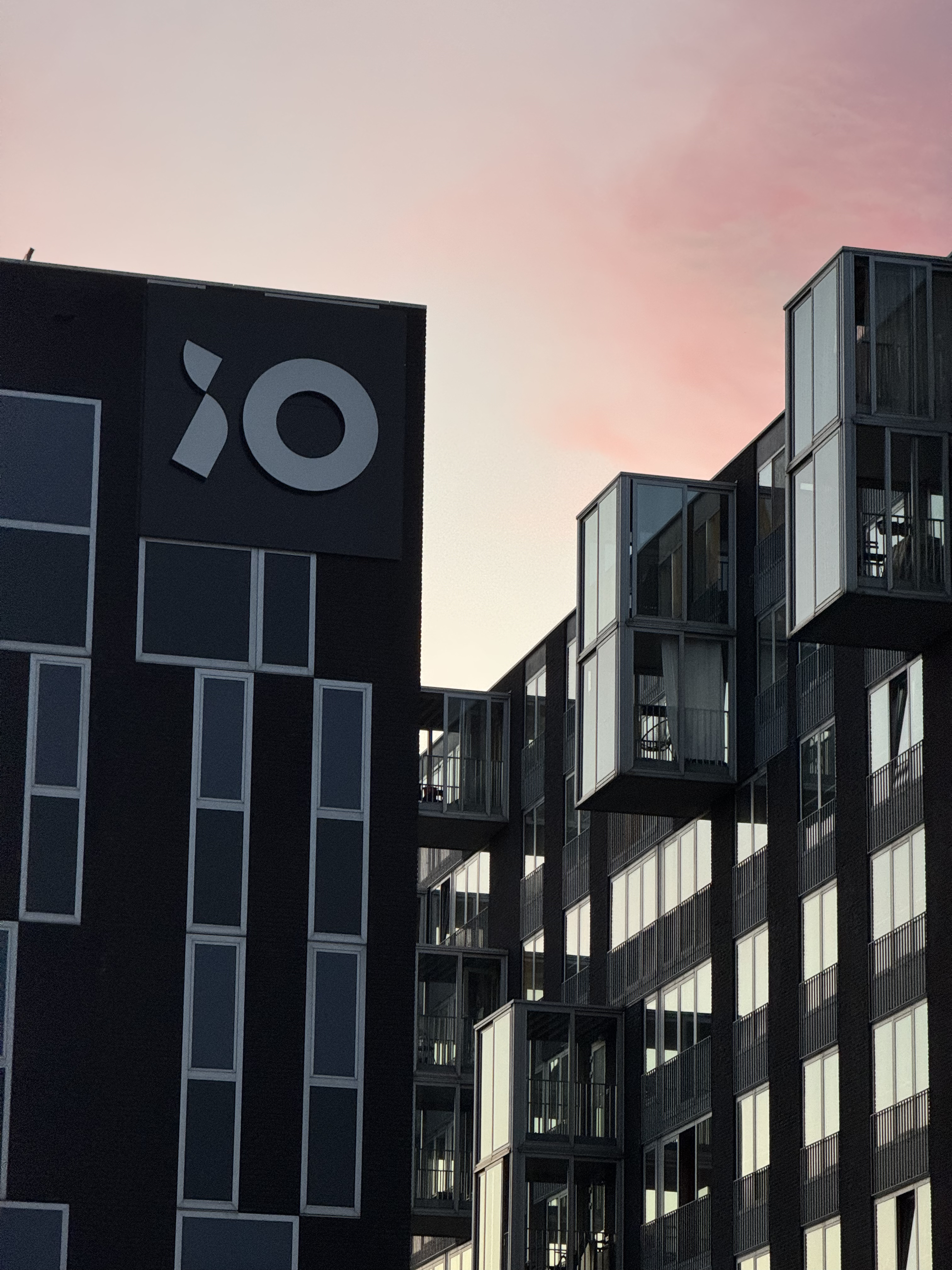 Mor bir günbatımını yansıtan cam bir bina